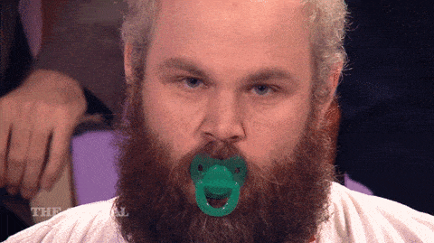 Un homme a une tétine de bébé dans la bouche.